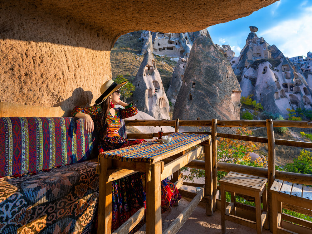 mujer-en-vestido-bohemio-sentado-en-la-casa-cueva-tradicional-en-capadocia-turquia