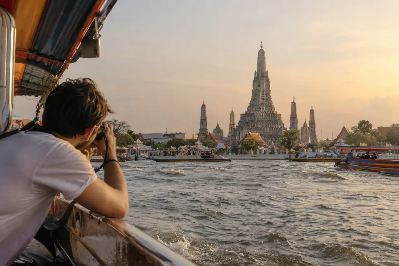 viajero fotografiando el templo Wat Arun desde el río en Bangkok, Tailandia